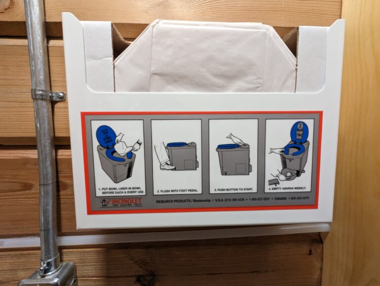 Close-up of an instructional guide for using the Incinolet electric toilet, showing steps for operation: The Incinolet Electric Toilet is as easy to use. Just drop in a liner, do your business, "flush", then press start.